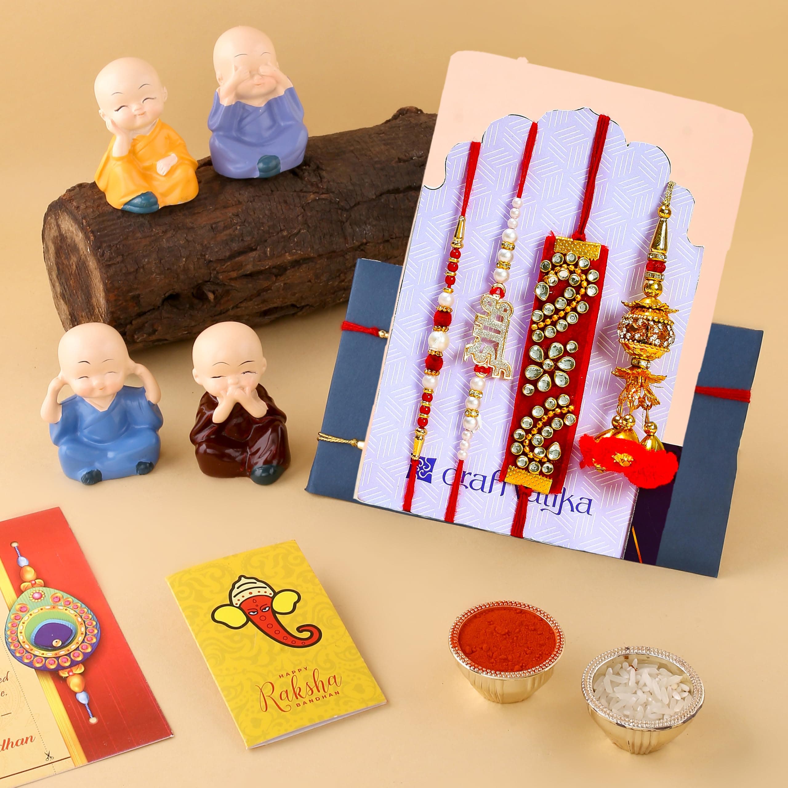 CraftVatika Rakhi for Bhaiya Combo Set - Rakhi for Bhai Bhabhi Kids - Family Combo Rakhis for Rakshabandhan Men Women - Miniature Buddha Monk Showpiece with Dora, Bhai, Lumba Valvet Rakhi, Card